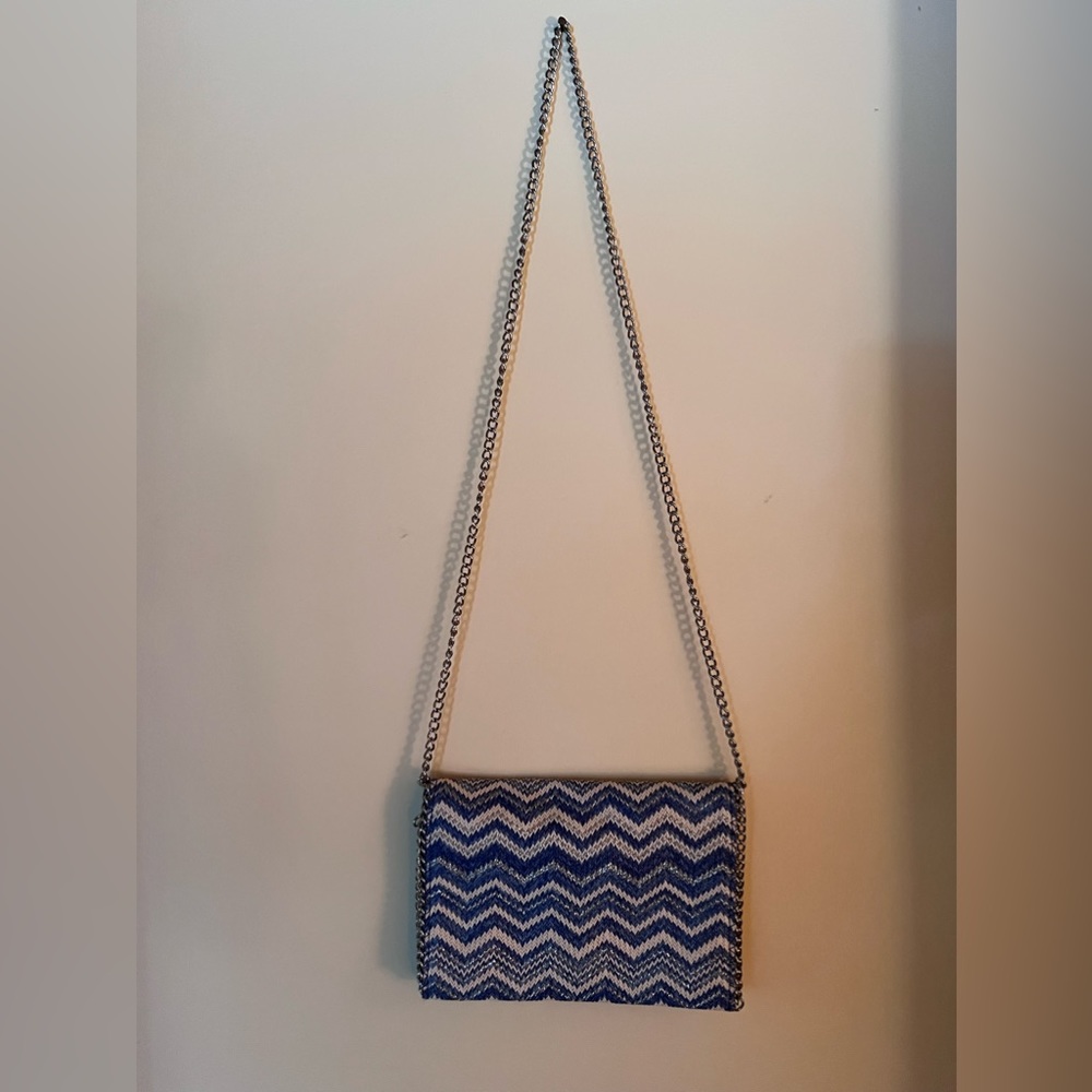 Clutch with optional silver chain. Interior zip pocket. Magnetic closure.